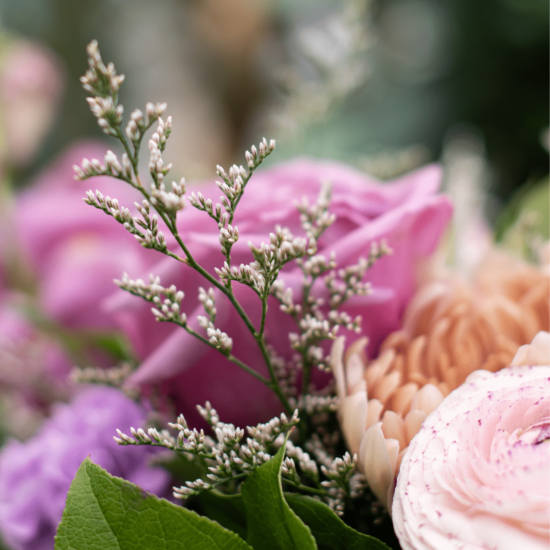 231 Close-up of a colorful flower bouquet with pink roses and assorted blossoms, highlighting delicate greenery.