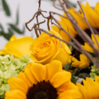 Bright yellow rose and sunflowers with green leaves and twigs, perfect for a vibrant floral arrangement.