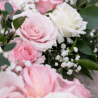 Pink and white rose bouquet with lush greenery and baby's breath flowers.