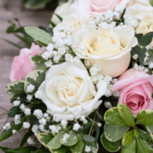 Close-up of a beautiful bouquet featuring white and pink roses with lush greenery and delicate baby's breath.