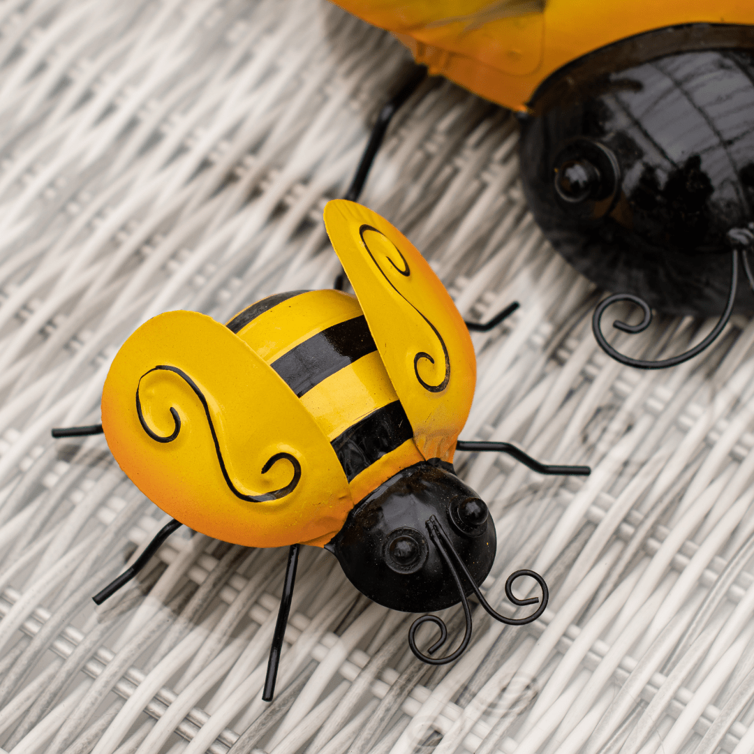Decorative yellow and black bee figurine on a wicker surface.