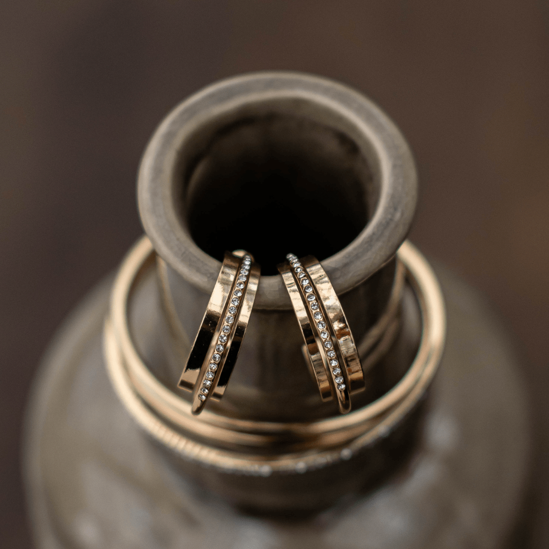 Gold diamond bangle bracelets elegantly displayed on a ceramic vase, showcasing luxury jewelry design.