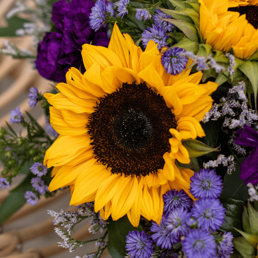 Vibrant sunflower bouquet with purple and blue accents, perfect for brightening any room or special occasion.