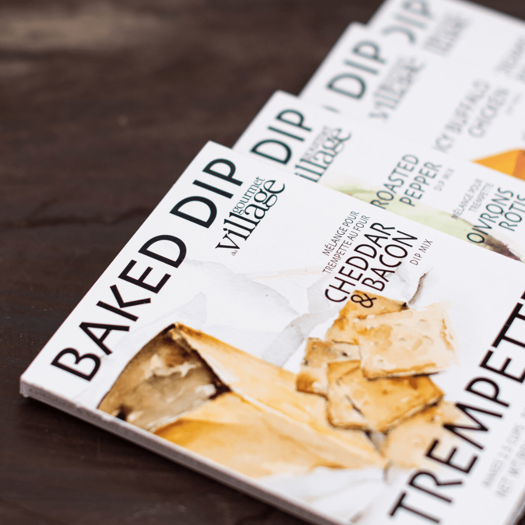 Gourmet Village baked dip mix packaging on display, featuring cheddar and bacon flavor. Ideal for dip enthusiasts.