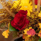 Vibrant autumn bouquet with a red rose, yellow daisy, and wheat stalks, capturing fall's colorful essence.