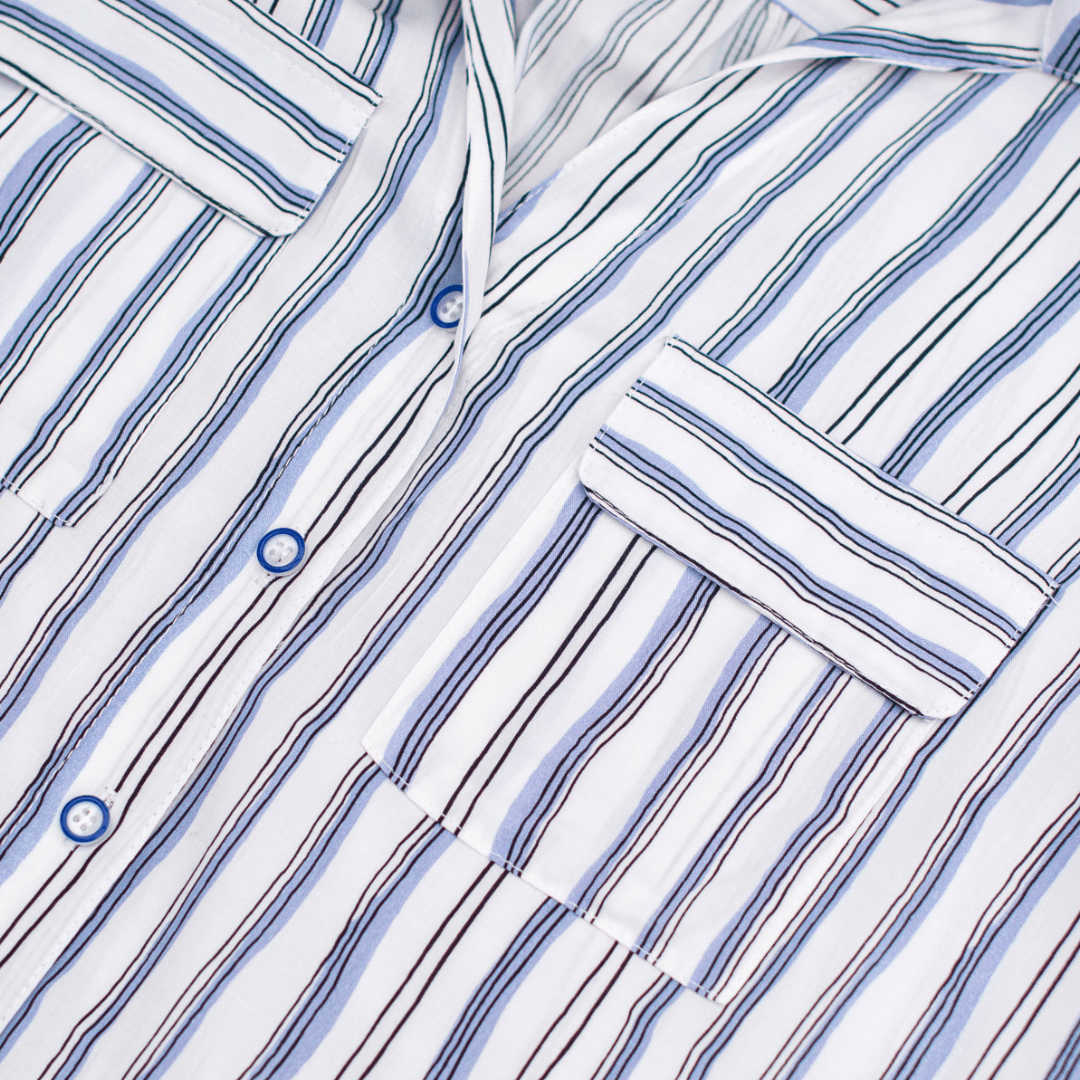 Close-up of a white shirt with blue and black vertical stripes and blue buttons.