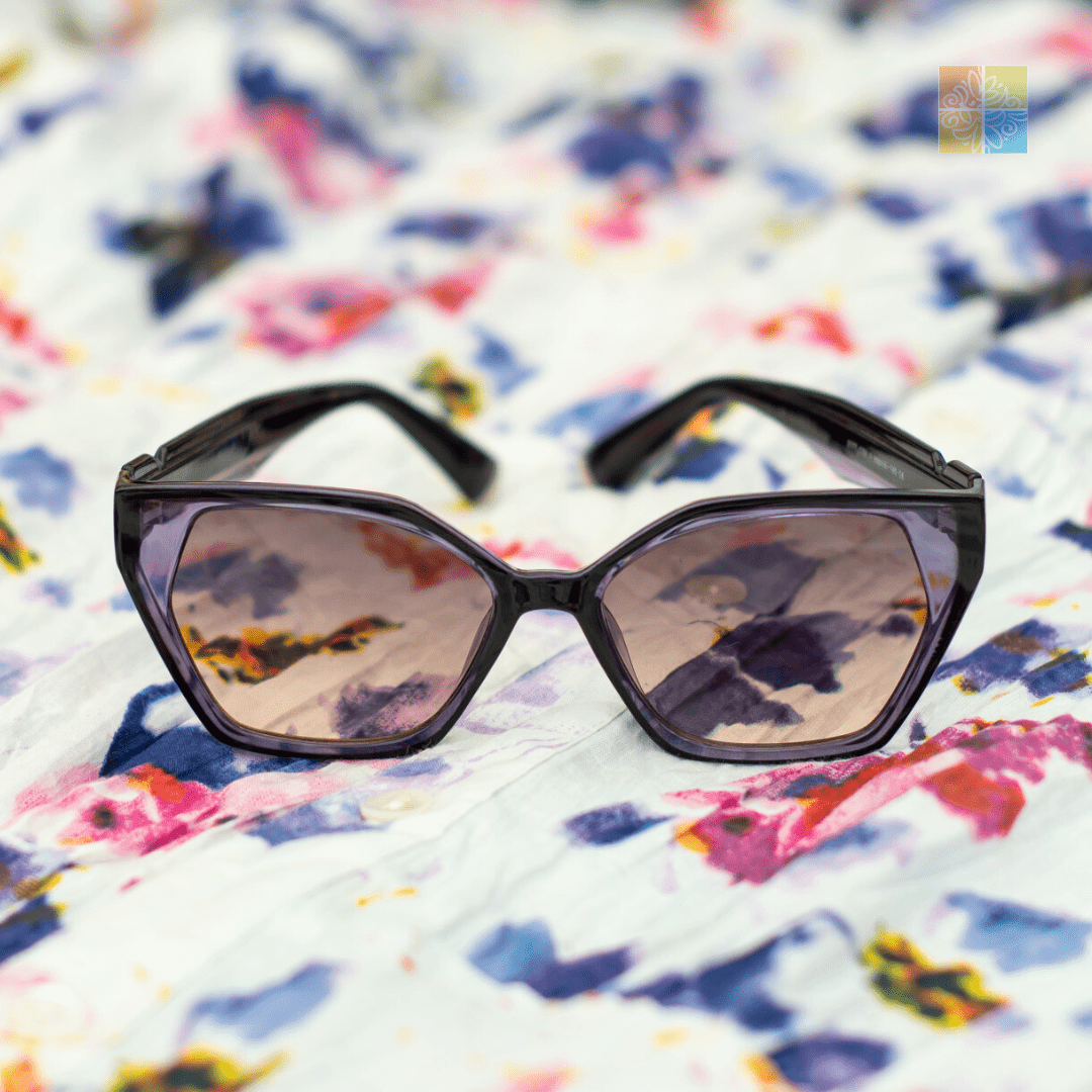 Stylish geometric sunglasses with tinted lenses on a colorful floral background. Fashion accessory image.