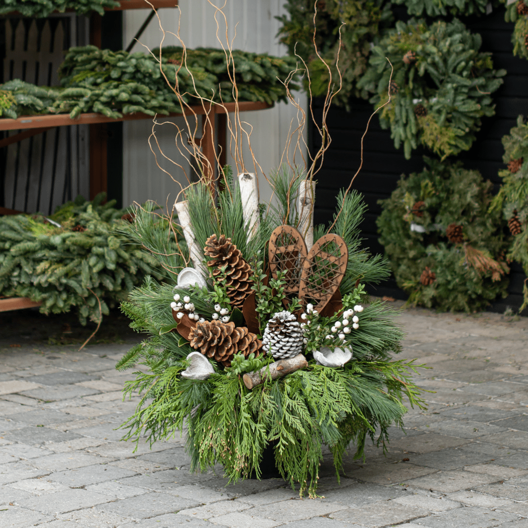Festive winter arrangement with pinecones, snowshoes, and greenery, perfect for holiday decoration and outdoor display.