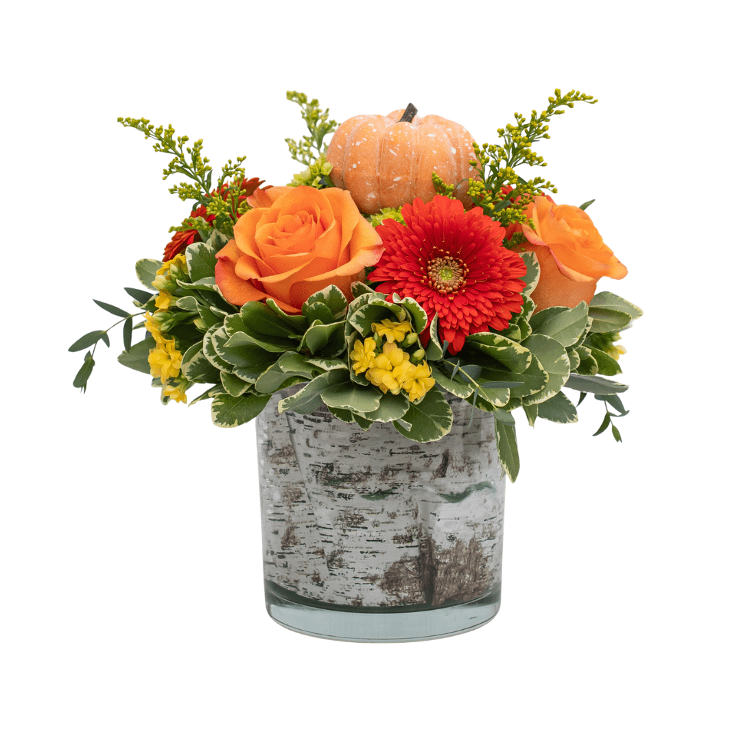 169 Festive fall floral centerpiece with orange roses, red gerbera, yellow blooms, greenery, and a small decorative pumpkin.
