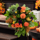 Vibrant autumn bouquet with orange roses, dahlias, and greenery, perfect for fall decor or seasonal celebrations.