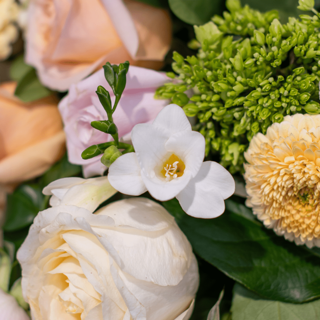 Mixed bouquet featuring white, pink, and cream flowers, including roses and greenery. Perfect for weddings or celebrations.