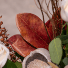 Beautiful autumn leaves and branches with white roses creating a vibrant nature-inspired floral arrangement.