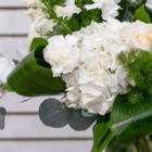 Elegant bouquet with white flowers and lush green leaves, perfect for weddings or special occasions.