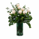 Elegant white roses in a green vase with lush greenery, perfect for weddings or home decor.