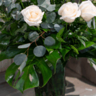 Elegant bouquet with white roses and lush green leaves, perfect for wedding or home decor.