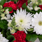 A vibrant bouquet of red roses, white daisies, and green leaves creates a stunning floral arrangement.