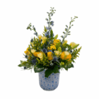 Elegant bouquet of yellow and orange flowers in a blue vase, featuring lush greenery and delicate blooms.