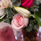 Close-up of a bouquet with pink roses, lilies, and eucalyptus leaves, perfect for romantic occasions and floral decor.