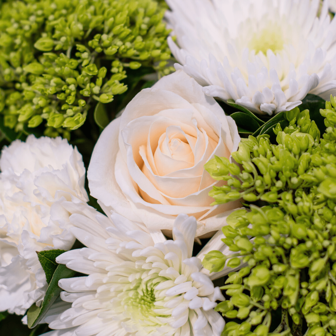 Elegant white and green floral arrangement with roses, chrysanthemums, and buds. Ideal for weddings or special events.