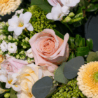 Close-up of a beautiful floral arrangement with pink roses, white lisianthus, and greenery for a stunning bouquet.