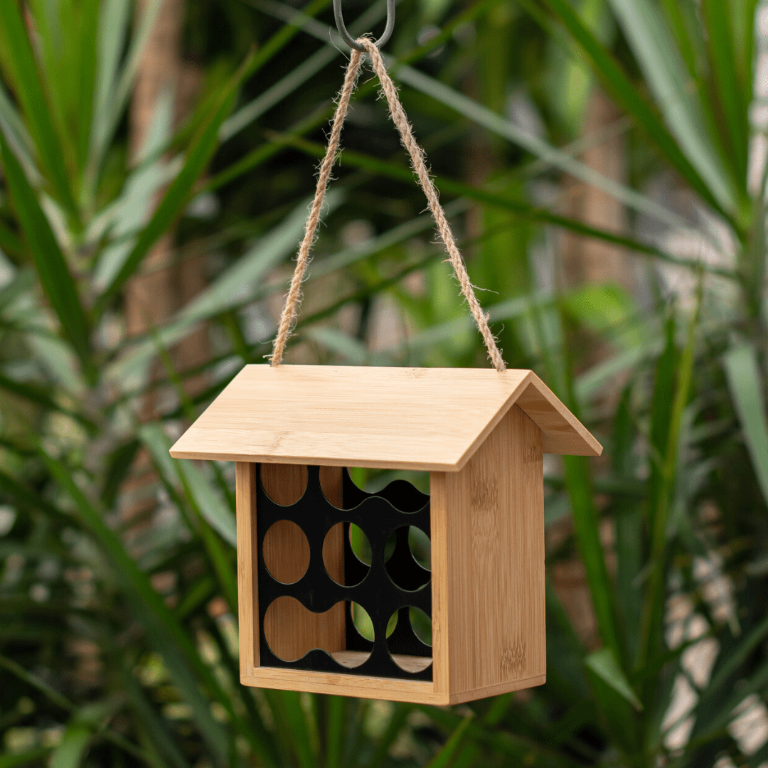 Eco-friendly bamboo insect house hanging in a garden, offering sustainable shelter for beneficial insects.