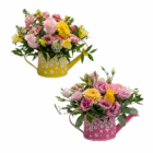 Colorful floral arrangements in decorative watering cans with pink and yellow flowers and greenery.