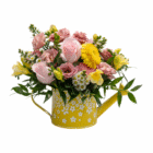 Colorful flower bouquet in a yellow daisy-patterned watering can, featuring pink and yellow blooms with green foliage.