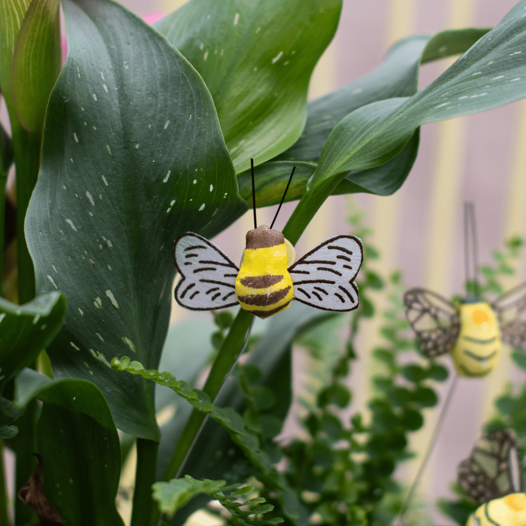 Cute decorative bee among lush green leaves, enhancing a garden-themed interior design.
