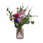 Elegant bouquet of mixed flowers in purple vase, featuring roses, calla lilies, and greenery, on white background.