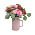 A fresh floral arrangement in a pink ceramic mason jar with pink roses, ranunculus, dianthus, and chocolate-coloured lisanthus.