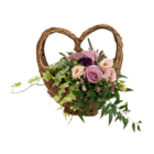 A floral arrangement with pink and purple roses, lisianthus, and dianthus, as well as variegated ivy, arranged in a wicker heart-shaped basket.