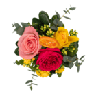 A view from above of a floral arrangement with a bright, light pink, and yellow rose, as well as yellow kalanchoes and a faux orange slice arranged in a wine glass with a watercolour floral design on it.