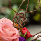 A close-up of the whimsical decorative brown branches in a fresh floral arrangement.
