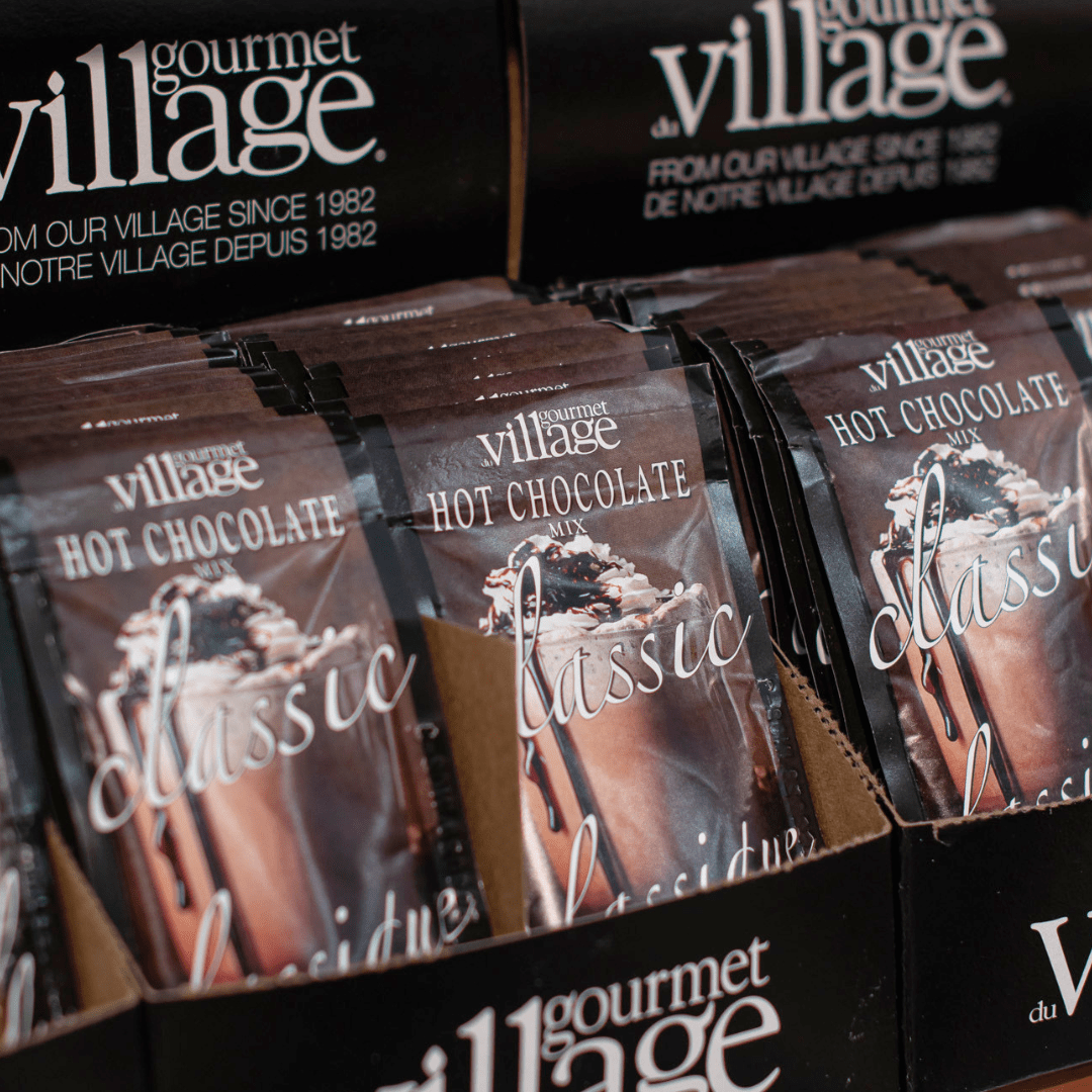 33 Brown packages of classic hot chocolate are lined up in a carboard display.