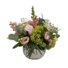 A pink and lime green floral arrangement in a clear glass round vase.