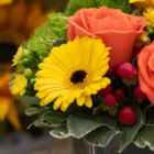 A close-up of a yellow gerbera with a dark center in a fresh floral arrangement.