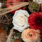 A close-up of a white rose in a fall floral arrangement.
