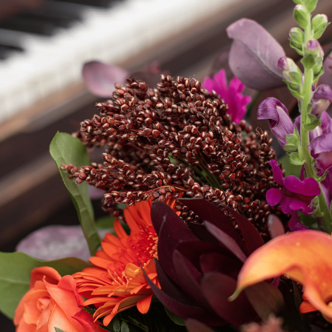 A close-up of brown broom corn in a floral bouquet.