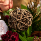 A close-up of a decorative brown root ball in a floral bouquet.