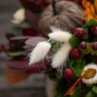 A close-up of a fluffy white bunny tail in a fall floral arrangement.