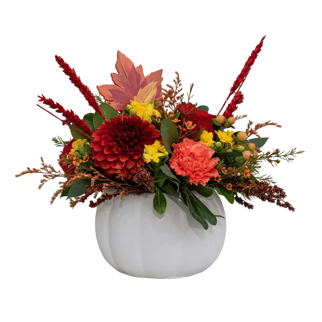 443 A fall floral arrangement in a white ceramic pumpkin with burnt-orange dahlias, peach carnations, yellow kalanchoes, etc