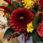 A close-up of a burnt-orange dahlia in a fall floral arrangement.