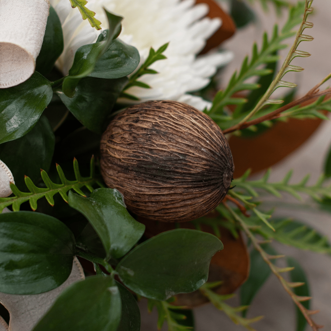 A close-up of a dried pod in a fall floral arrangement.