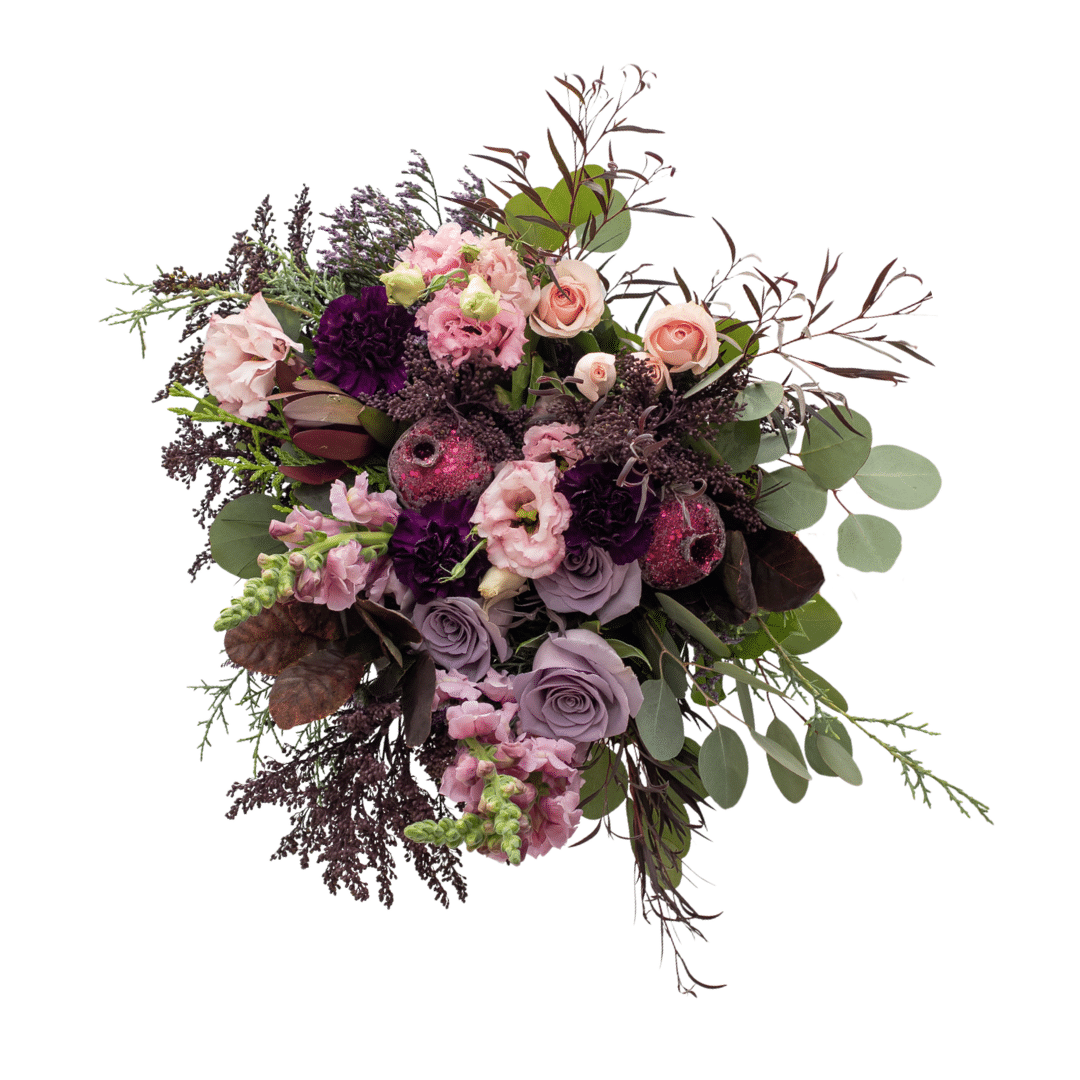 An above view of a berry-toned bouquet with roses, carnations, lisianthus, snap dragons, etc.