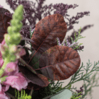 A close-up of burgundy smokebush leaves in a berry-toned bouquet.