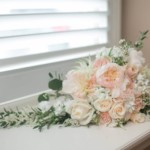 Elegant bridal bouquet with pastel roses and greenery on a windowsill, perfect for romantic wedding inspirations.