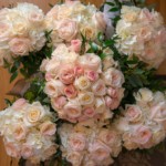 Bouquet of pink and white roses with greenery, perfect for weddings or romantic occasions. Elegant floral arrangement.